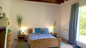 ein Schlafzimmer mit einem Bett und einem Fenster in der Unterkunft Le Gite D'origne in Origne