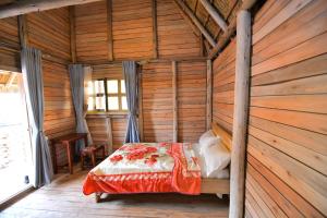 a bedroom with a bed in a wooden room at Rustic cabin in Masaka