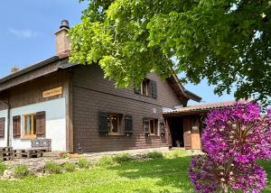 a house with purple flowers in front of it at Le Refuge du Trappeur in Crémines