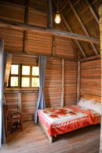 a bedroom with a bed in a wooden house at Rustic cabin in Masaka +6 photos