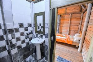 a bathroom with a sink and a bunk bed at Rustic cabin in Masaka