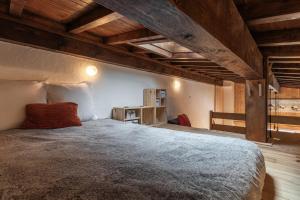 a large bed in a room with wooden ceilings at Les Chaumes - T3 moderne piscine in Cordon +20 photos