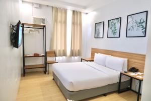 a hotel room with a bed and a television at Bambu Suites in Puerto Princesa City