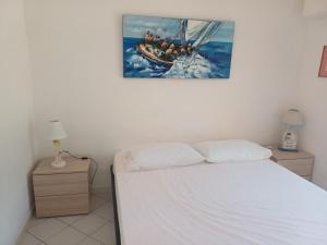 une chambre avec un lit avec un tableau sur le mur dans l'établissement casa del merlo, à Marina di Campo Airport