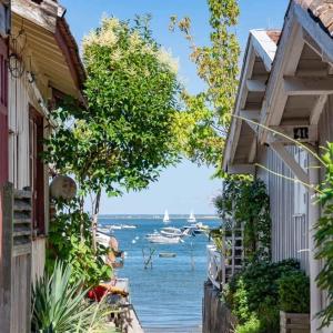 een uitzicht op de oceaan vanaf twee gebouwen bij Joli duplex 5 pers avec piscine - Cap Ferret in Lège-Cap-Ferret