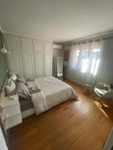 a bedroom with a large bed and a wooden floor at Comme à la maison B and B in Carcassonne
