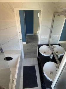 a bathroom with two sinks and a mirror at Comme à la maison B and B in Carcassonne +12 photos