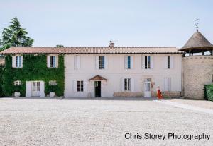 a person walking in front of a large white building at Chambres d'hôtes du Château de Seguin in Lignan-de-Bordeaux