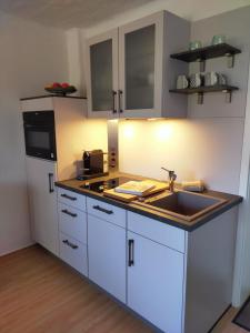 a kitchen with a sink and a counter top at Lille Koje - Dein eigenes Strand-Apartment mit Panoramablick über die Ostsee in Kronsgaard