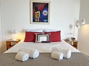 a bedroom with a large white bed with red pillows at Lady Delmar Marina Olhao By Junto ao Mar in Olhão