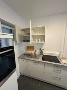 a kitchen with white cabinets and a sink at F5 - 2 Zimmer Wohnung in Offenbach