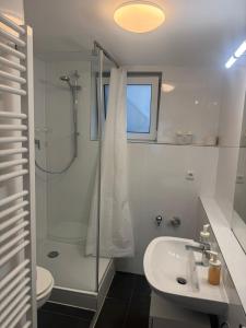 a white bathroom with a shower and a sink at F5 - 2 Zimmer Wohnung in Offenbach