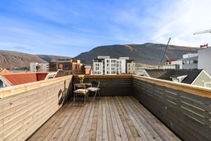 a balcony with two chairs on a wooden deck at The Guest Apartment in Tromsø