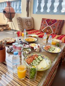 a table with plates of food and drinks on it at Waveside surf house in Tamraght Oufella