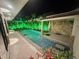 einen Pool mit grüner Beleuchtung in der Nacht in der Unterkunft Villa Sensara Sunset Luxury 3BR in Uluwatu