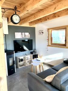 ein Wohnzimmer mit einer Couch und einer Uhr an der Wand in der Unterkunft Chalet individuel en montagne in La Forclaz