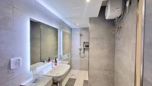 un baño con lavabo y ducha en The Guesthouse By SH, en Phnom Penh 31 fotos más