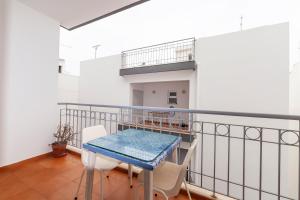 Un balcón con una mesa azul y sillas blancas. en Central 1 Bed Apartment, en Lagos