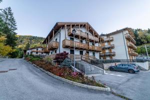 Un edificio grande con un coche aparcado en un estacionamiento. en Charming Civetta, en Alleghe