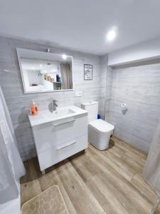 a bathroom with a white sink and a toilet at Petit Suite Alegria in Ubrique