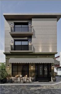 a building with tables and chairs in front of it at Alkioni Boutique Hotel in Pýli