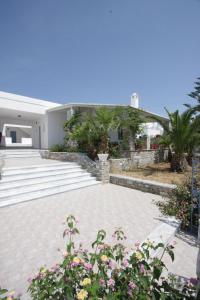 a courtyard of a house with flowers and plants at Manos Apartments in Megas Gialos - Nites