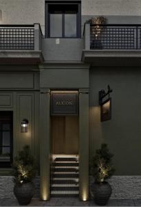 an entrance to an apartment building with two potted plants at Alkioni Boutique Hotel in Pýli +11 photos