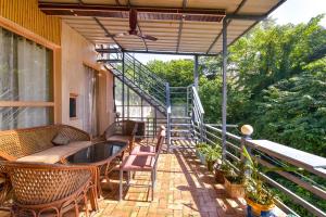 a balcony with a table and chairs and a staircase at FabHotel Doon Classic Homestay in Dehradun