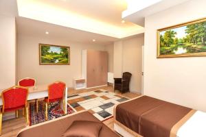 a bedroom with a bed and a desk and chairs at Diplomat Suites Hotel in Baku