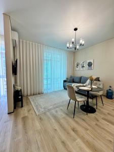 a living room with a table and a couch at A-Six Apartment ЖК Достар in Karagandy
