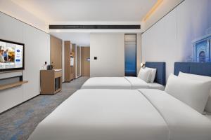 Una cama o camas en una habitación de Hampton by Hilton Nanjing North Railway Station