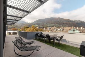 a patio with a table and chairs on a balcony at Le Méribel - Terrasse 83m2 - Vue Mont-Blanc in Sallanches