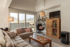a living room with a couch and a table at Le Méribel - Terrasse 83m2 - Vue Mont-Blanc in Sallanches