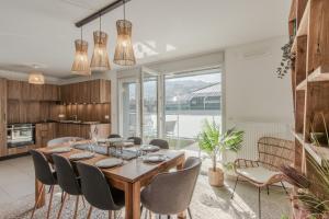 a kitchen and dining room with a wooden table and chairs at Le Méribel - Terrasse 83m2 - Vue Mont-Blanc in Sallanches