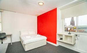 Un dormitorio con una pared de acento rojo y una cama en Bright Convenient Central Coventry Budget Studio, en Coventry