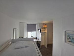 a room with a bed and a desk and a window at The Badger Inn in Carbis Bay