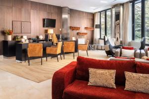a living room with a red couch and chairs at Meliá Sol y Nieve in Sierra Nevada