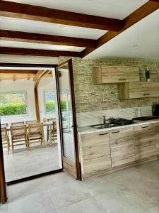 a kitchen with wooden cabinets and a table and chairs at Nouveauté Gite la virée verte in Vagney