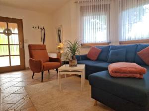 a living room with a blue couch and a chair at Ferienwohnung im Herzen der Lausitz in Groß Düben