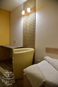 a bedroom with a bed and a desk and a table at Fenyves fogadó in Ásotthalom