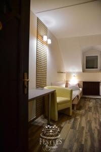 a hotel room with a bed and a table at Fenyves fogadó in Ásotthalom