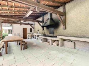 a large outdoor kitchen with benches and a stove at La Passerelle de la Doller in Reiningue