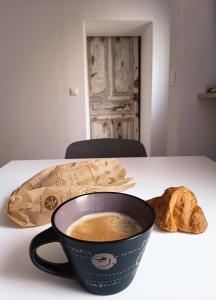 a cup of coffee and a croissant on a table at Mafolie in Pierrelatte