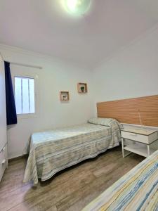 ein Schlafzimmer mit zwei Betten und einem Schreibtisch und einem Fenster in der Unterkunft Bungalows Teresa in Playa del Ingles + 39 Fotos