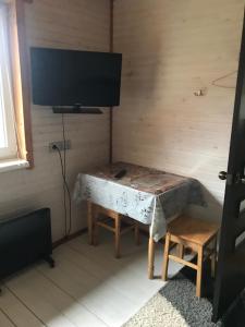 a room with a table with a tv on a wall at Ромашка in Sheshory