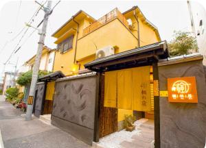 un edificio amarillo al costado de una calle en 楓の宿1號館, en Osaka
