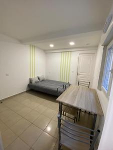 a room with a bed and a table in it at Le Palmier in Valras-Plage