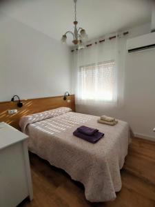 a bedroom with a bed with two towels on it at El Salón de Arriba in El Real de San Vicente +4 photos