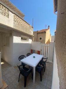 a white table and chairs on a patio at Le Palmier in Valras-Plage