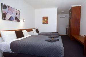 a hotel room with two beds and a desk at Glynlea Motel in Horsham +124 photos
